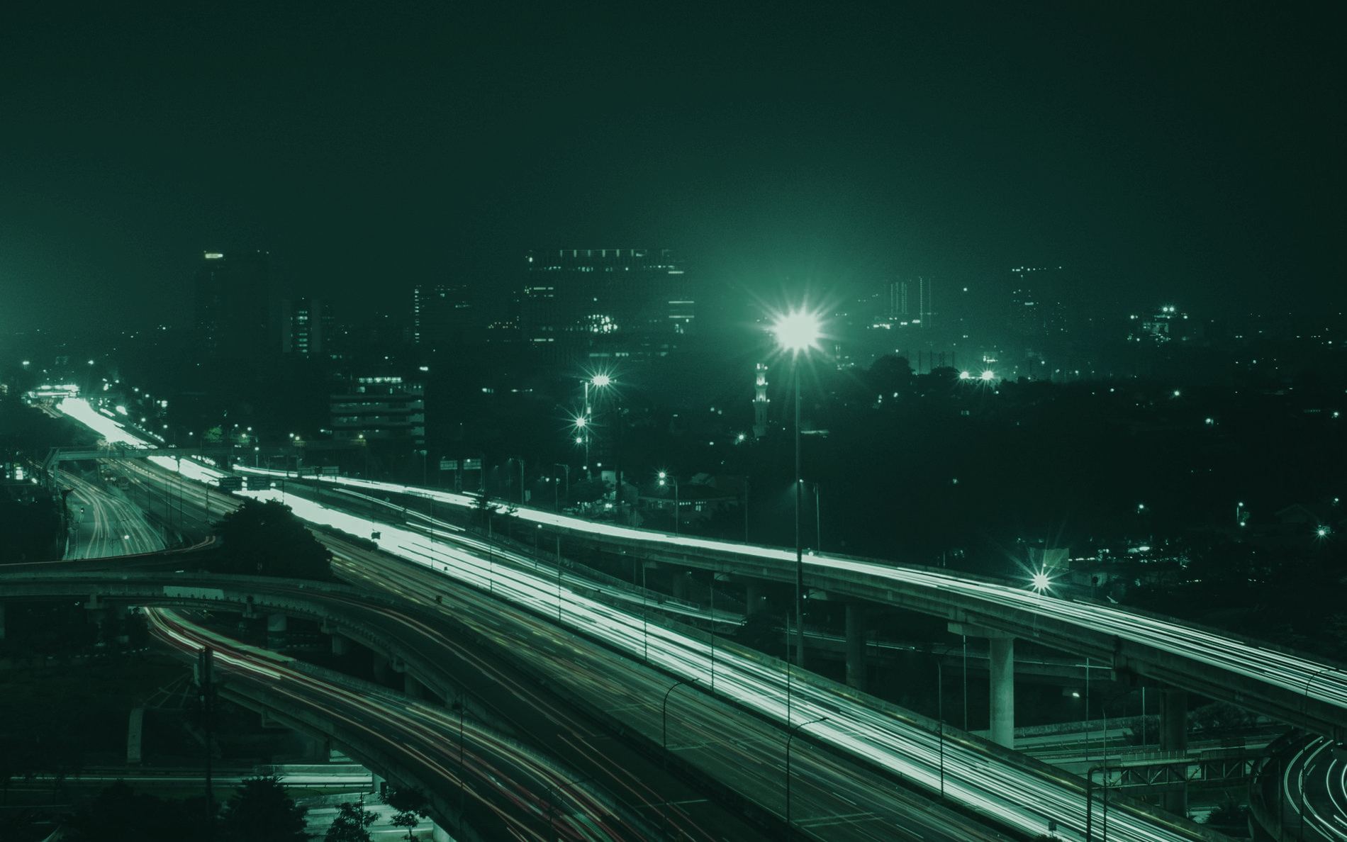 夜の高速道路を流れる車のライトの帯
